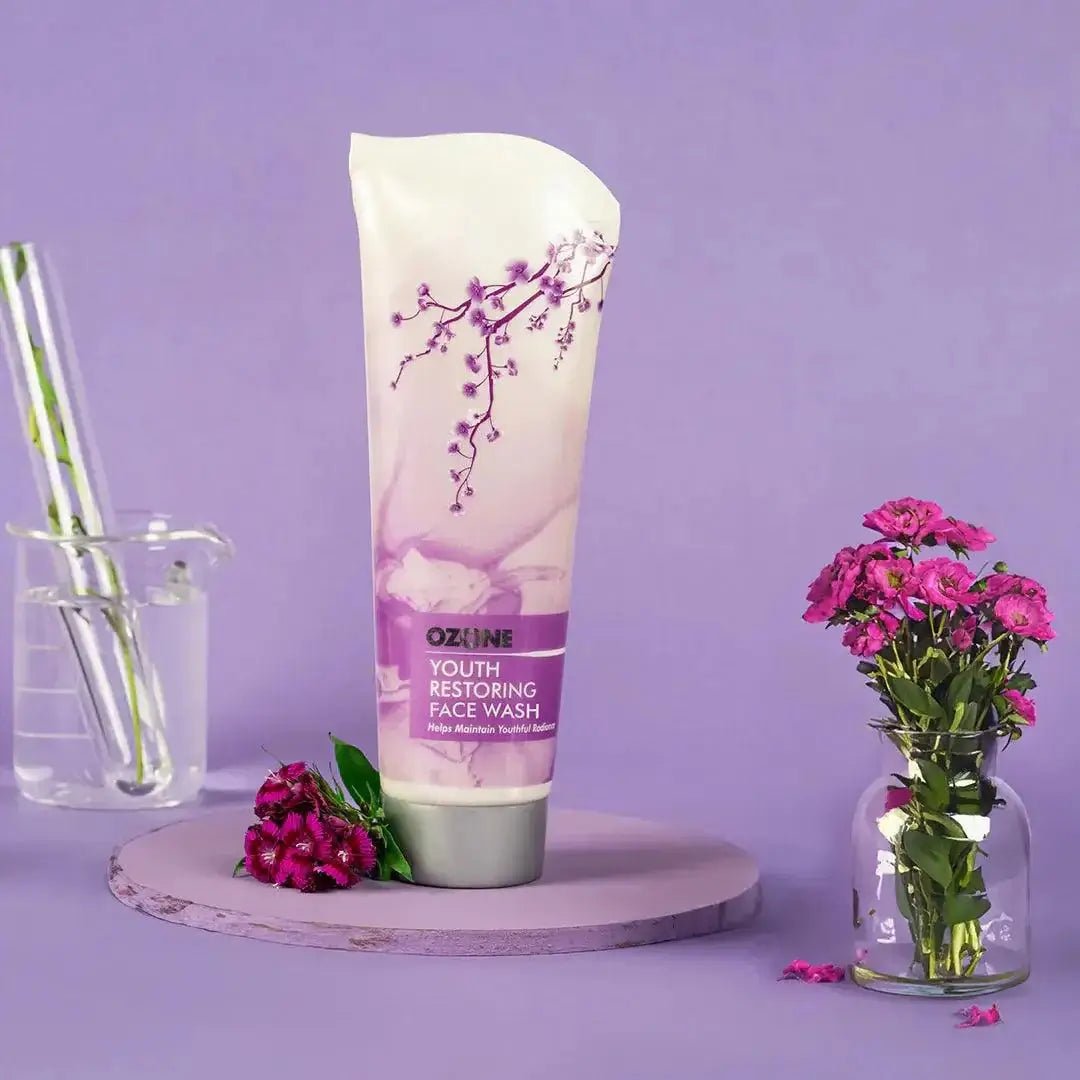 Youth Restoring Face Wash 100g tube with floral elements on a purple background, enhances skin's radiance and youthful glow.